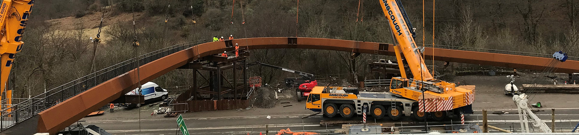 A steel footbridge being craned into position
